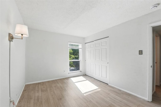 444 N Clay Ave Unit 2N, Kirkwood, MO 63122 - unfurnished bedroom featuring a textured ceiling, light wood finished floors, baseboards, and a closet