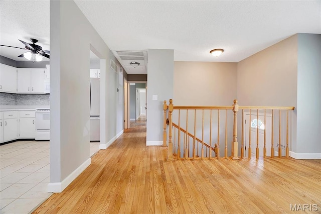 229 Stillbrook Estates Dr, Fenton, MO 63026 - corridor with an upstairs landing, light wood-type flooring, and a textured ceiling