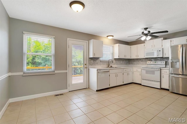 229 Stillbrook Estates Dr, Fenton, MO 63026 - kitchen featuring white appliances, light countertops, tasteful backsplash, a textured ceiling, and white cabinetry