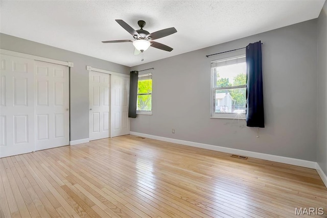229 Stillbrook Estates Dr, Fenton, MO 63026 - unfurnished bedroom with light wood-style flooring, two closets, and a ceiling fan