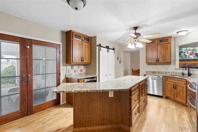 8 Baron Ridge Ct, Ofallon, MO 63366 - kitchen with appliances with stainless steel finishes, light wood finished floors, brown cabinetry, and healthy amount of natural light
