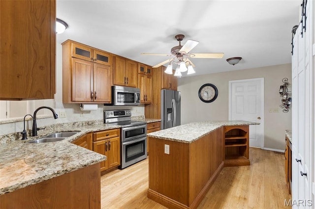 8 Baron Ridge Ct, Ofallon, MO 63366 - kitchen with stainless steel appliances, brown cabinetry, and light wood finished floors