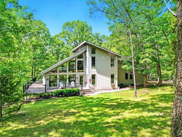 back of property with a yard and a wooden deck