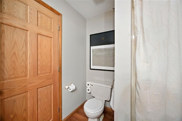 full bathroom featuring toilet, wood finished floors, baseboards, and curtained shower