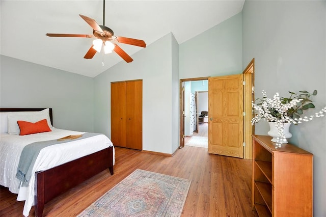 bedroom featuring high vaulted ceiling, light wood finished floors, baseboards, ceiling fan, and a closet