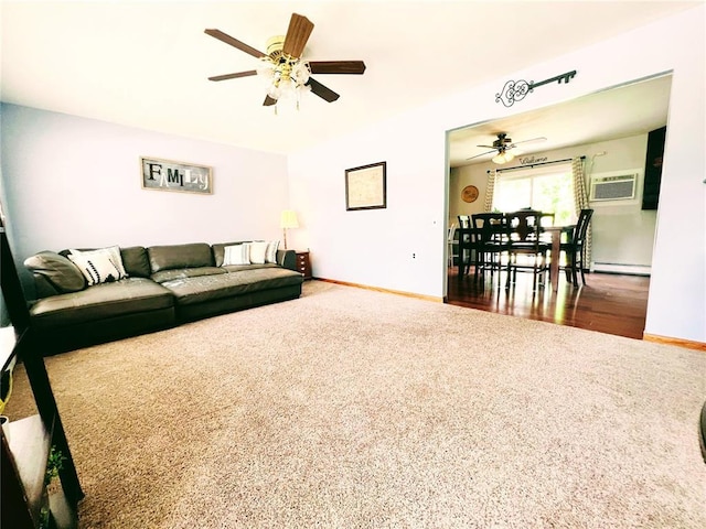 carpeted living area with a ceiling fan, a baseboard heating unit, baseboards, and an AC wall unit