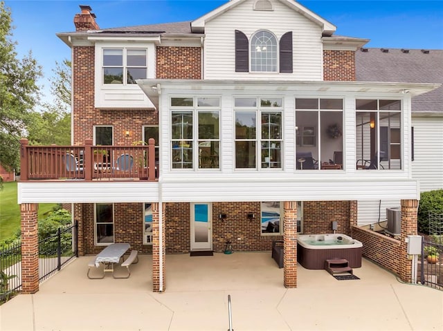 214 Townview Ct, Wentzville, MO 63385 - rear view of house featuring a patio area, a hot tub, brick siding, a balcony, and a sunroom