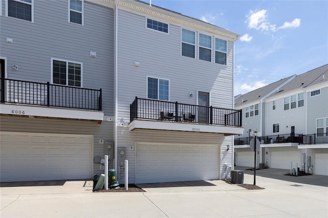 8000 Central Park Dr, Richmond Heights, MO 63117 - rear view of property featuring central air condition unit, a balcony, an attached garage, and driveway