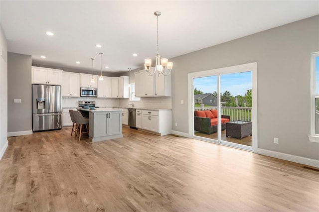 207 Still Creek Dr, Lake St Louis, MO 63367 - kitchen featuring appliances with stainless steel finishes, a chandelier, backsplash, white cabinetry, and recessed lighting