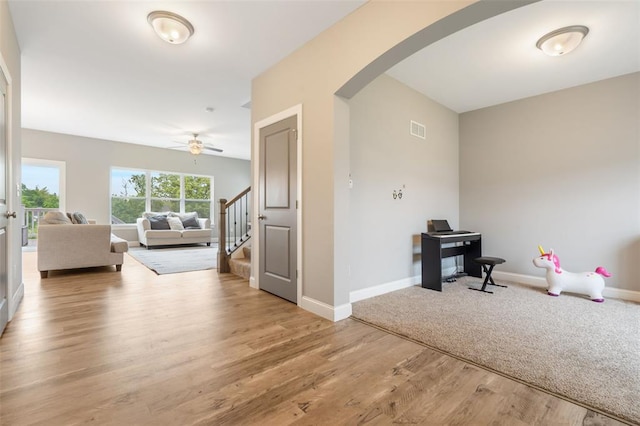 207 Still Creek Dr, Lake St Louis, MO 63367 - entrance foyer featuring arched walkways, stairs, ceiling fan, light wood-type flooring, and baseboards