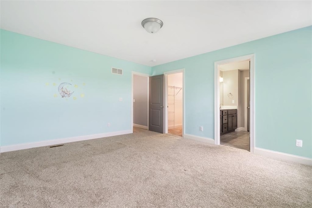 207 Still Creek Dr, Lake St Louis, MO 63367 - unfurnished bedroom featuring light carpet, a walk in closet, baseboards, a closet, and connected bathroom