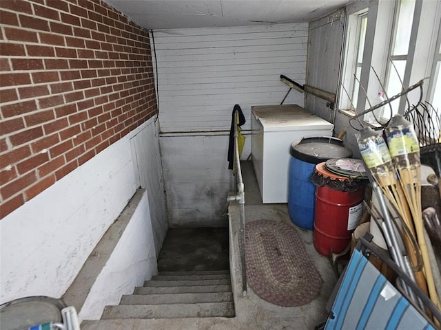 staircase with washer / dryer and unfinished concrete floors