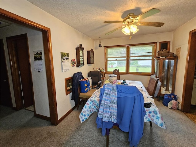 carpeted dining area with a textured ceiling, ceiling fan, and baseboards