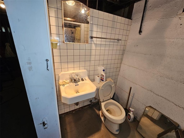 bathroom featuring concrete floors, toilet, and a sink
