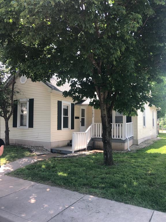 view of front of home with a porch and a front yard
