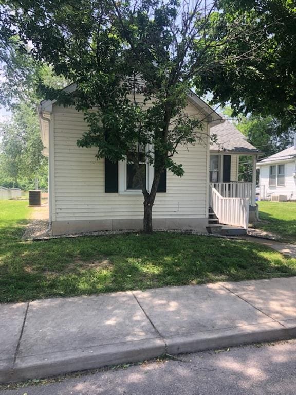 view of side of home with a yard