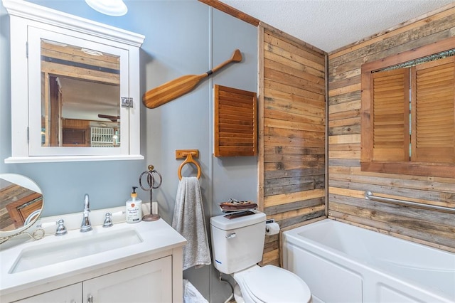 full bath featuring wood walls, toilet, a tub, vanity, and a textured ceiling