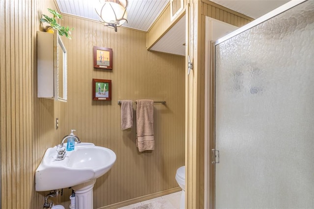 bathroom with a stall shower, toilet, and a sink