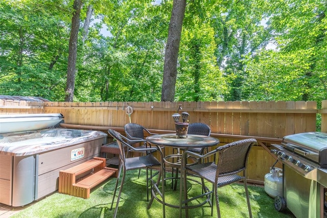 view of patio with grilling area, fence, and a hot tub