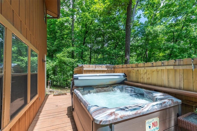 wooden terrace with a hot tub and fence