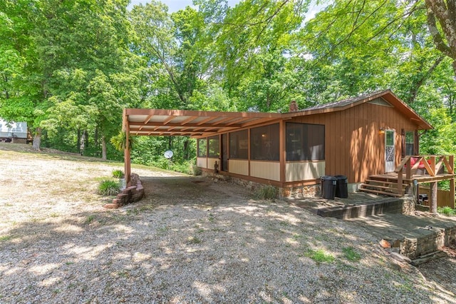 view of front of home featuring driveway, a carport, and a chimney