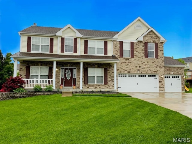 view of front of property with concrete driveway, a front lawn, a garage, and a porch