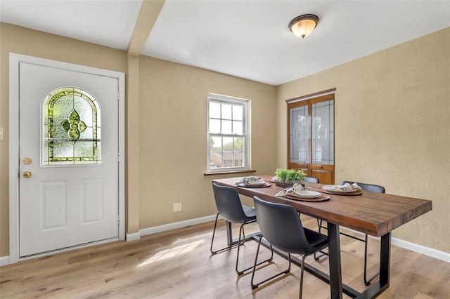 dining area featuring light wood finished floors and baseboards