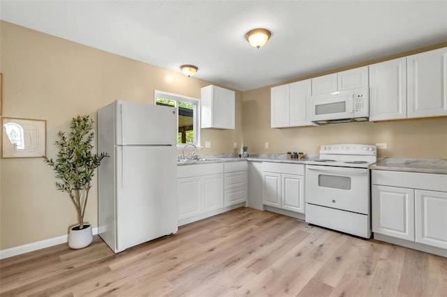 kitchen with white appliances, light wood-style floors, white cabinets, and light countertops