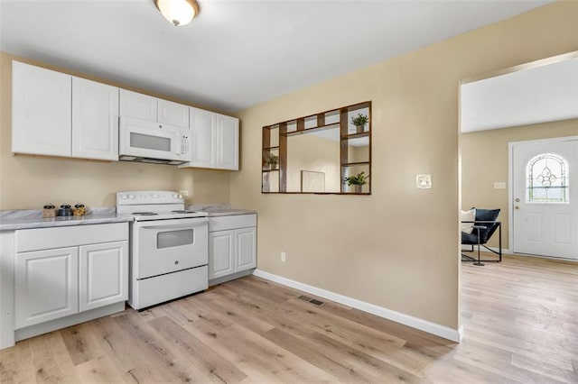 kitchen featuring white appliances, light wood finished floors, baseboards, and white cabinets