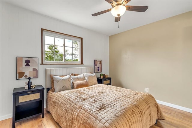 bedroom featuring wood finished floors, baseboards, and a ceiling fan