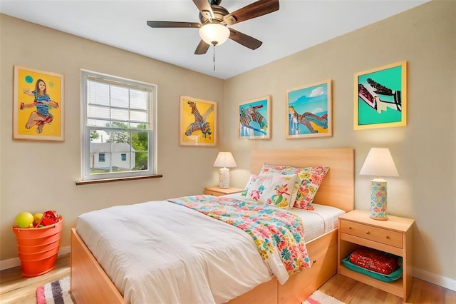 bedroom featuring wood finished floors, baseboards, and a ceiling fan