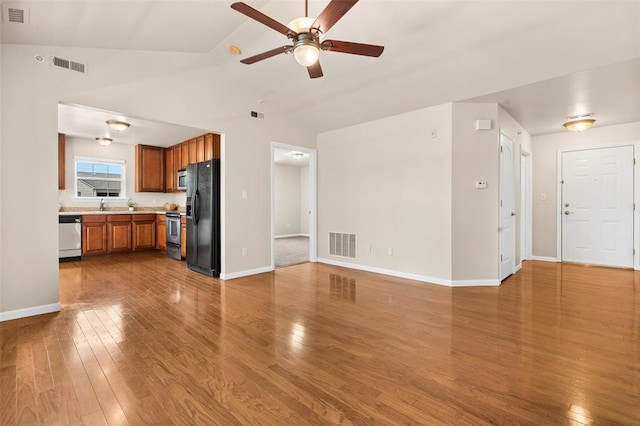 1131 Welsh Dr, Lake St Louis, MO 63367 - unfurnished living room featuring wood finished floors, a ceiling fan, baseboards, a sink, and vaulted ceiling