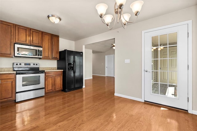 1131 Welsh Dr, Lake St Louis, MO 63367 - kitchen featuring stainless steel appliances, brown cabinetry, light countertops, a chandelier, and light wood finished floors