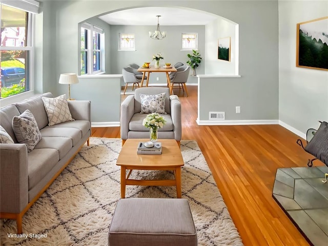 6504 Hoffman Ave, Saint Louis, MO 63139 - living area featuring arched walkways, a chandelier, baseboards, and wood finished floors