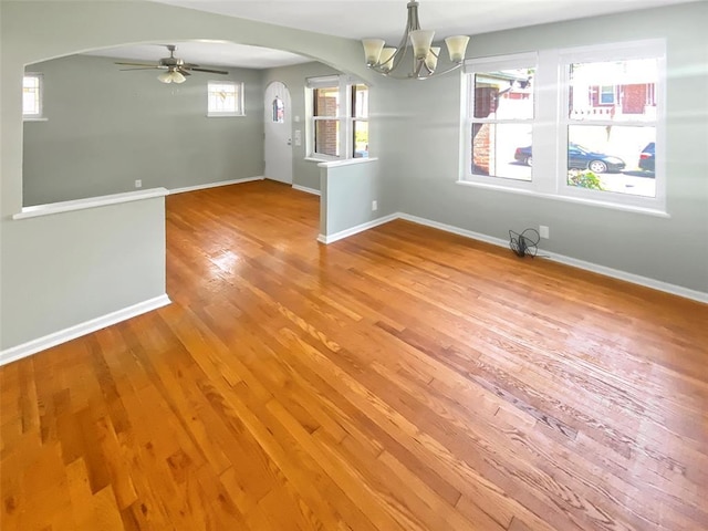 6504 Hoffman Ave, Saint Louis, MO 63139 - spare room featuring arched walkways, light wood finished floors, a chandelier, baseboards, and ceiling fan
