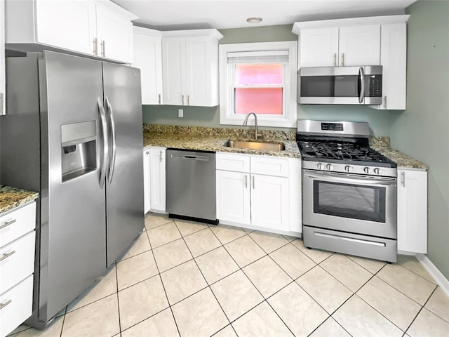 6504 Hoffman Ave, Saint Louis, MO 63139 - kitchen featuring appliances with stainless steel finishes, a sink, white cabinetry, stone counters, and light tile patterned flooring