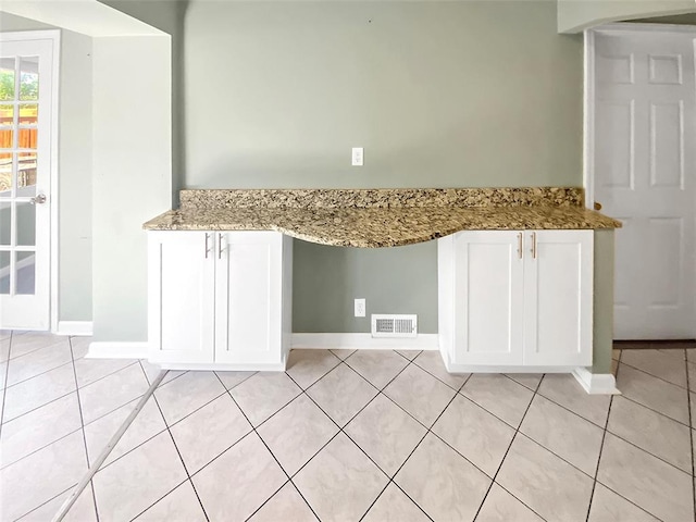 6504 Hoffman Ave, Saint Louis, MO 63139 - kitchen with light tile patterned floors, white cabinetry, baseboards, and light stone counters