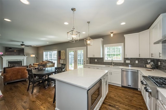 1026 Barry Ct, Kirkwood, MO 63122 - kitchen featuring appliances with stainless steel finishes, a sink, a ceiling fan, a fireplace, and recessed lighting