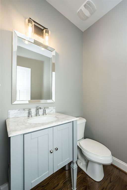 1026 Barry Ct, Kirkwood, MO 63122 - bathroom featuring toilet, vanity, baseboards, wood finished floors, and lofted ceiling