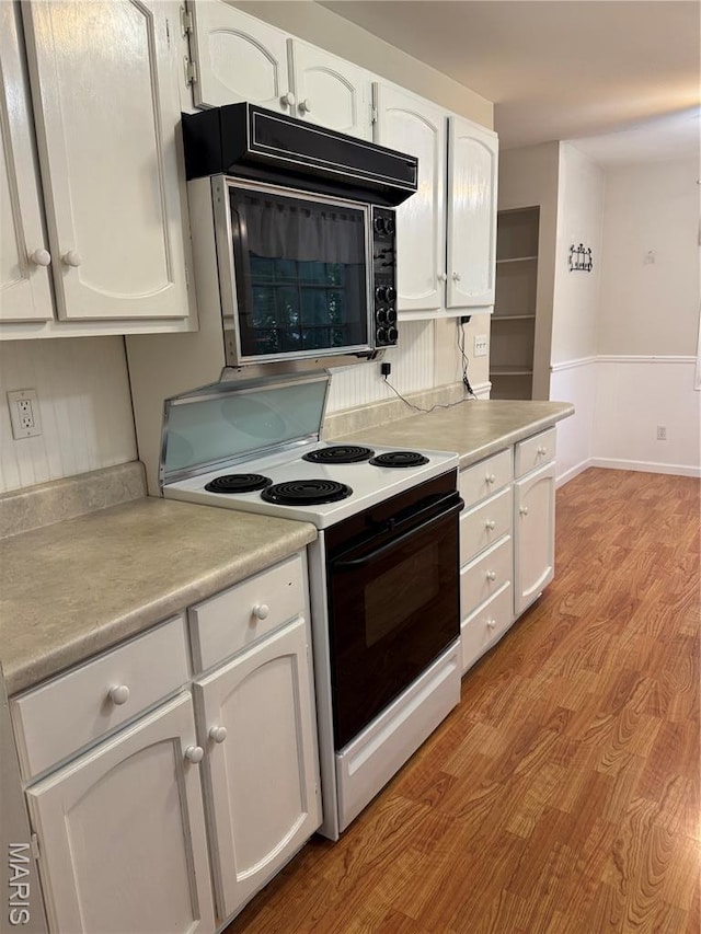 5810 White Pine Dr, Saint Louis, MO 63129 - kitchen with electric stove, black microwave, white cabinets, light countertops, and wainscoting