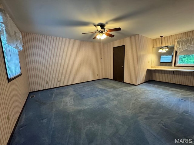 5810 White Pine Dr, Saint Louis, MO 63129 - unfurnished living room featuring wallpapered walls, a ceiling fan, carpet floors, and healthy amount of natural light