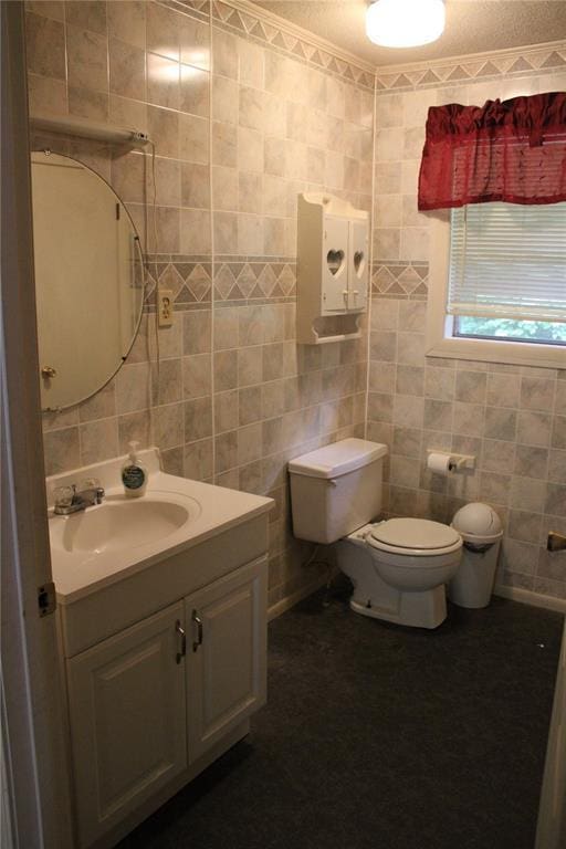 bathroom featuring tile walls, toilet, and vanity