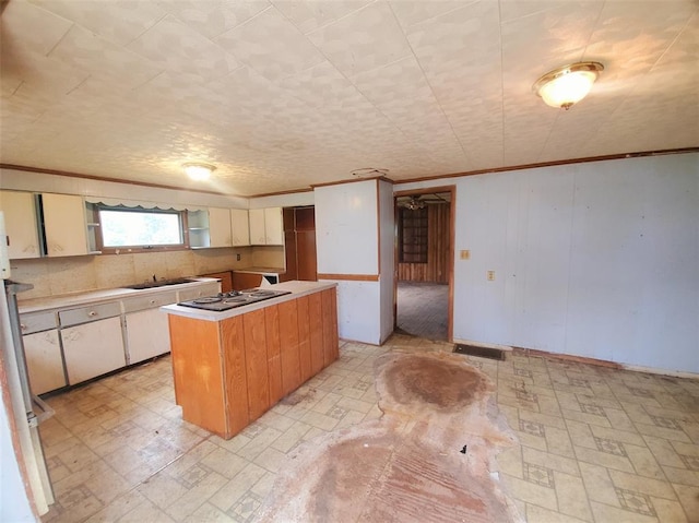517 N 4th St, La Grange, MO 63448 - kitchen featuring ornamental molding, electric stovetop, a center island, a sink, and light countertops