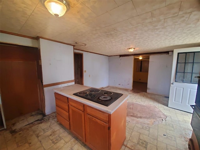 517 N 4th St, La Grange, MO 63448 - kitchen featuring black electric cooktop, light countertops, a kitchen island, and brown cabinets