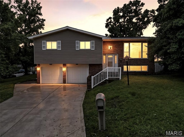 2649 Georgia Dr, Arnold, MO 63010 - bi-level home with brick siding, a garage, driveway, and a lawn