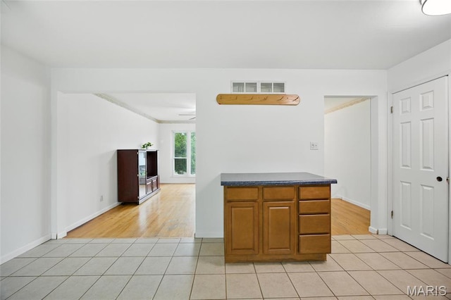 2649 Georgia Dr, Arnold, MO 63010 - kitchen featuring light tile patterned floors, dark countertops, and brown cabinets