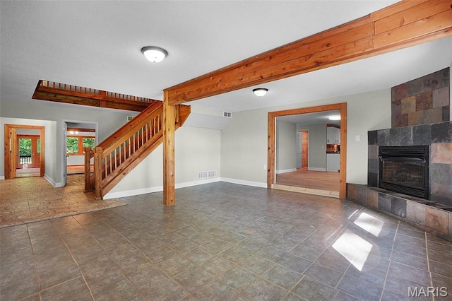 14938 Pike 139, Bowling Green, MO 63334 - unfurnished living room with stairs, a tile fireplace, and baseboards