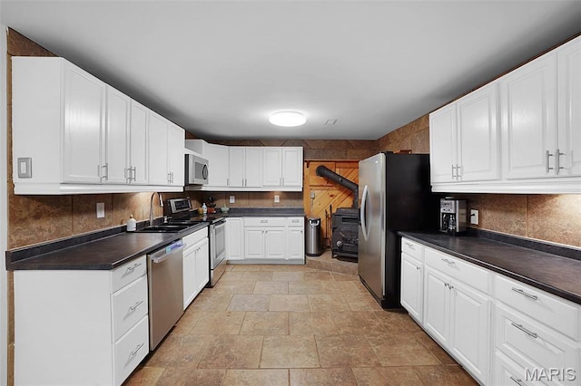 14938 Pike 139, Bowling Green, MO 63334 - kitchen featuring stainless steel appliances, a sink, dark countertops, backsplash, and stone finish flooring