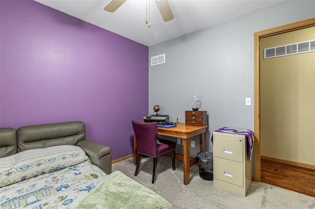 carpeted office space with ceiling fan and baseboards