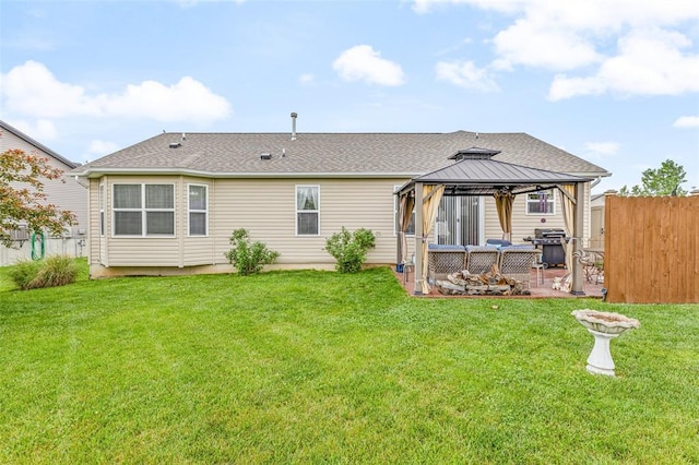 back of property with a gazebo, a patio, and a shingled roof